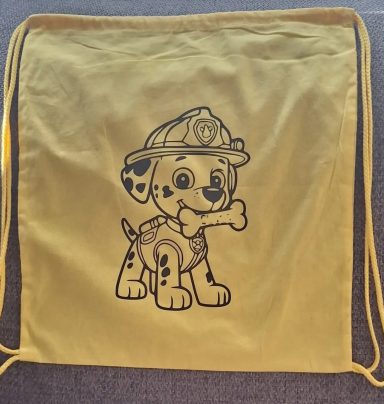 nachhaltige Geschenkverpackung Gelber Rucksack mit einem cartoonhaften Hund im Feuerwehroutfit und Knochen.
